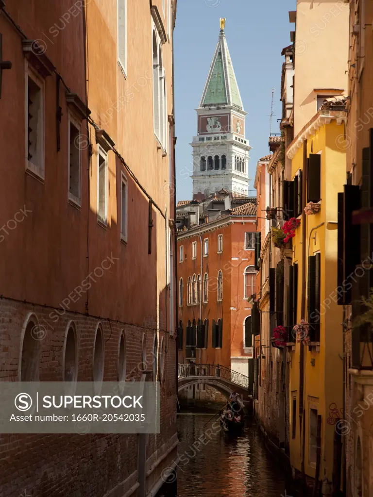 Italy, Venice, man in gondola, narrow canal and buildings