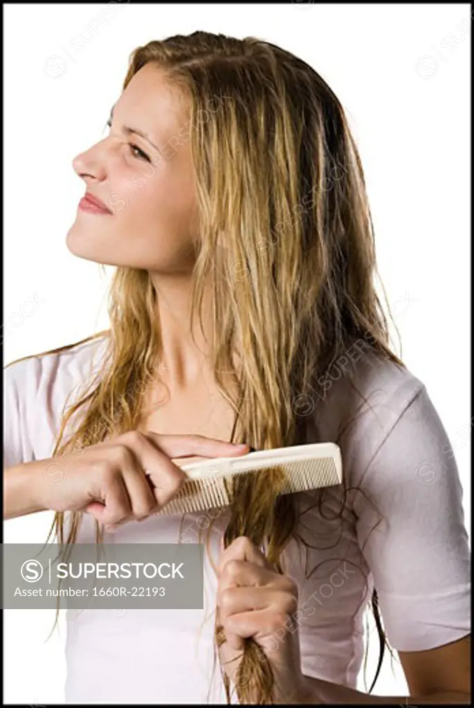 Young woman combing hair.