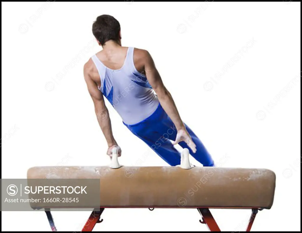 Male gymnast performing on vaulting horse