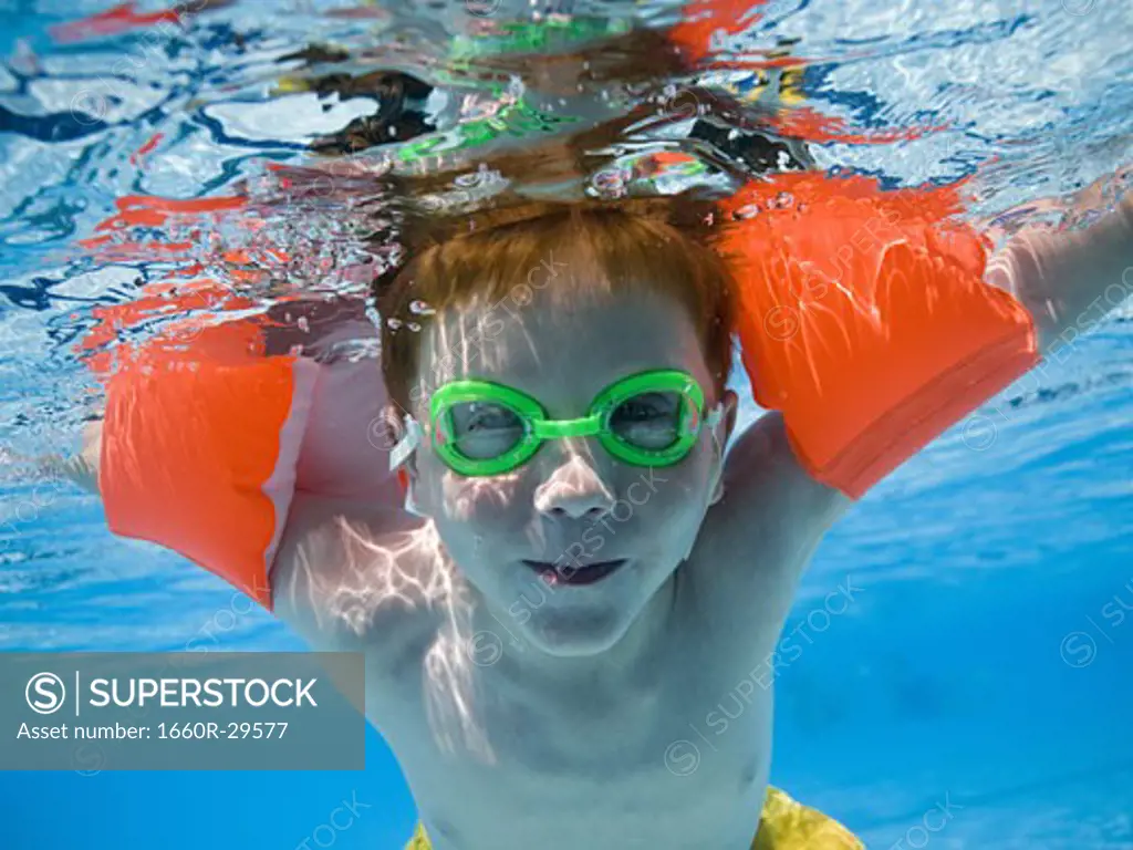 Boy swimming underwater in pool