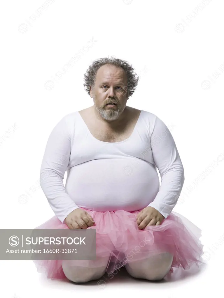 Obese man in tutu kneeling and praying