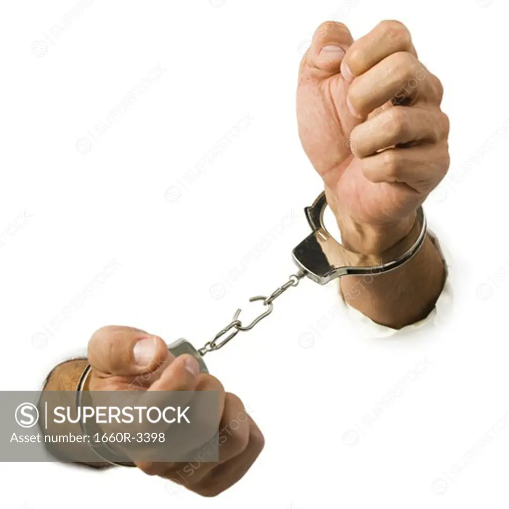 Close-up of hands trying to break out of handcuffs