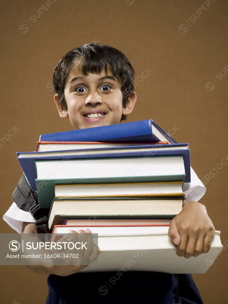 Boy holding pile of textbooks