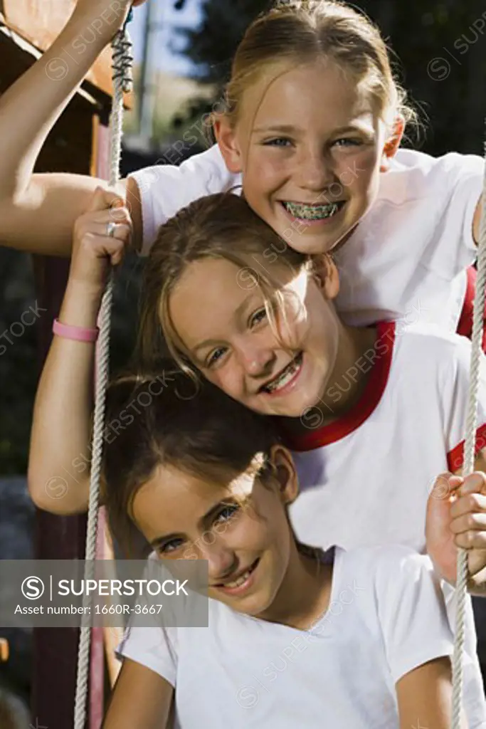 Portrait of three girls sitting on a swing