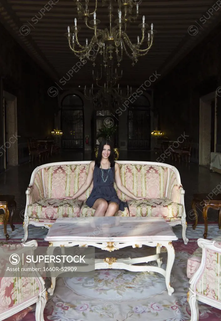 Italy, Venice, Young woman sitting in luxury room