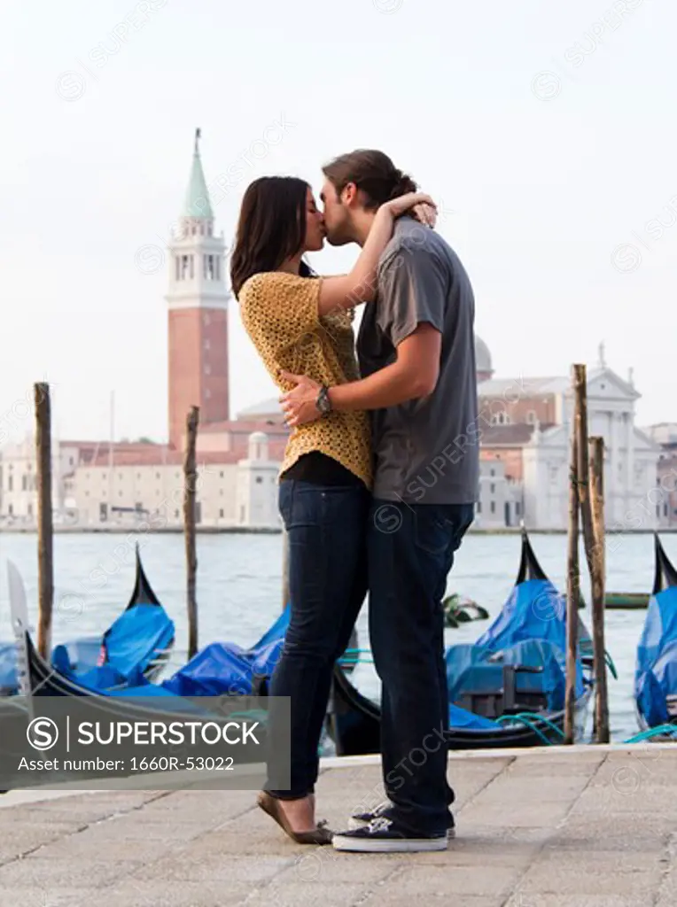 Italy, Venice, Young couple kissing in front of San Giorgio Maggiore Church