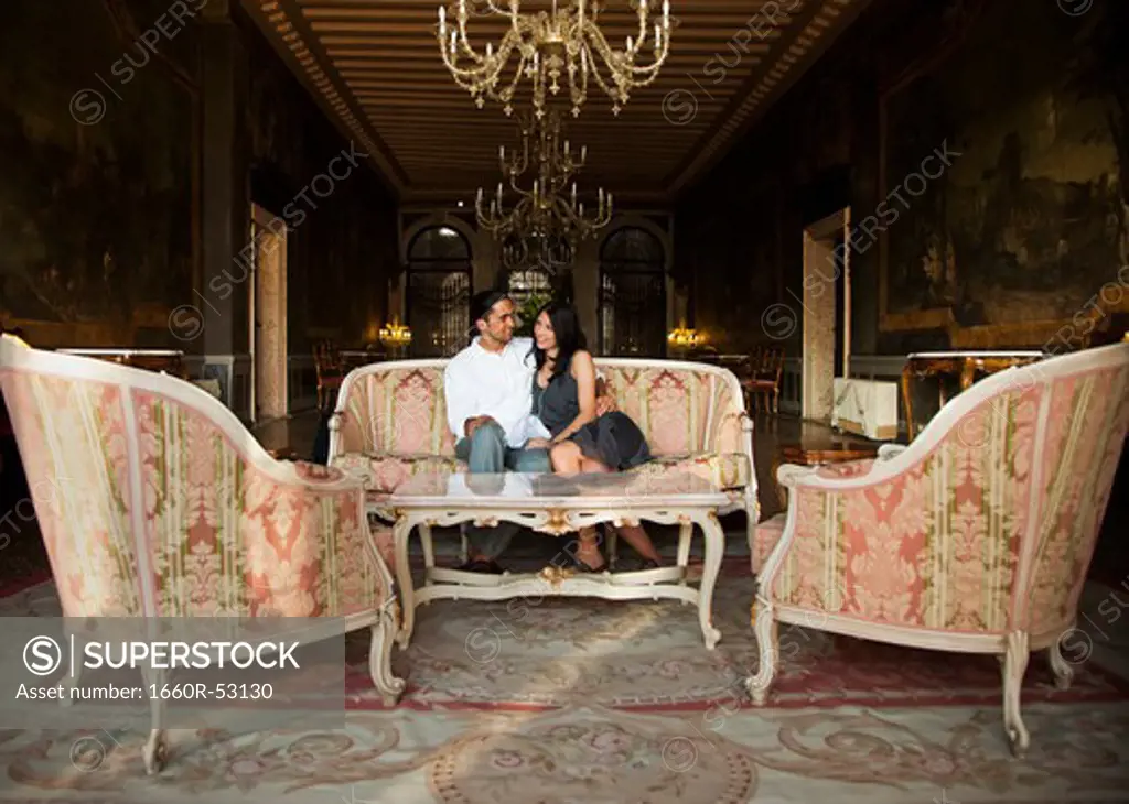 Italy, Venice, Young couple sitting in elegant lounge