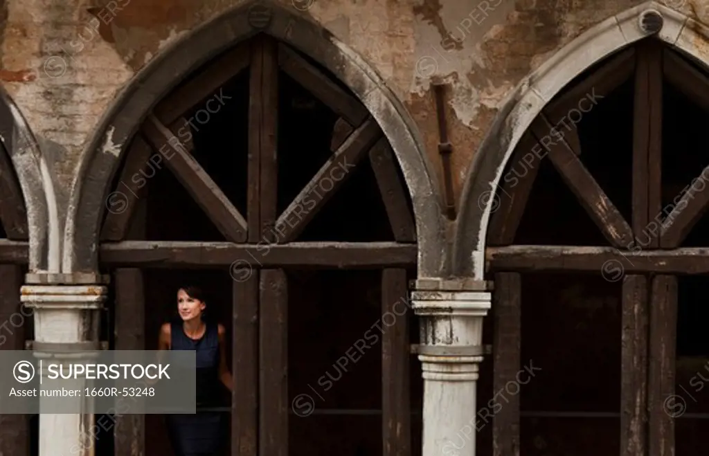 Italy, Venice, Woman standing in arcade