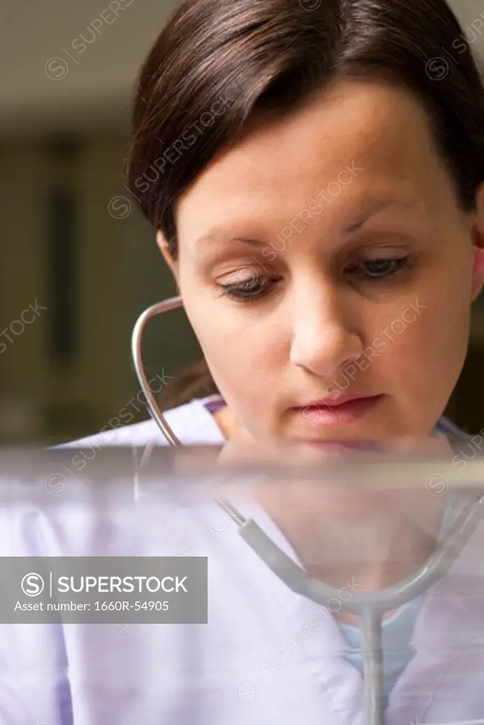 Nurse examining newborn in incubator