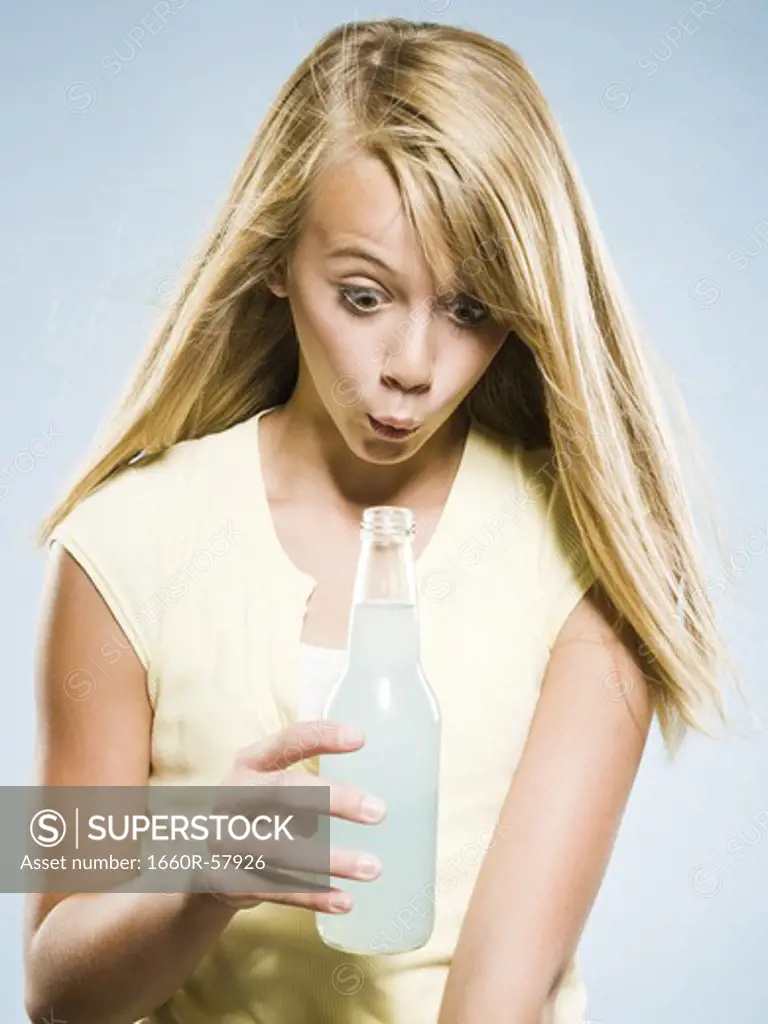 Girl looking into soda bottle