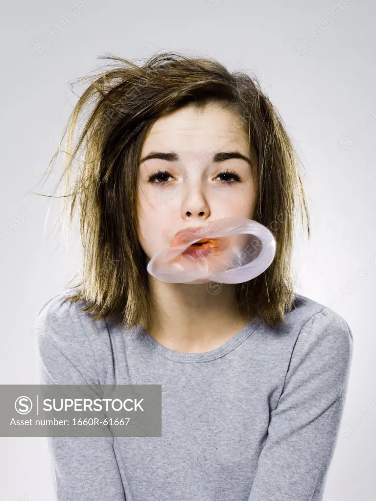 girl with a messy appearance popping a bubble gum bubble