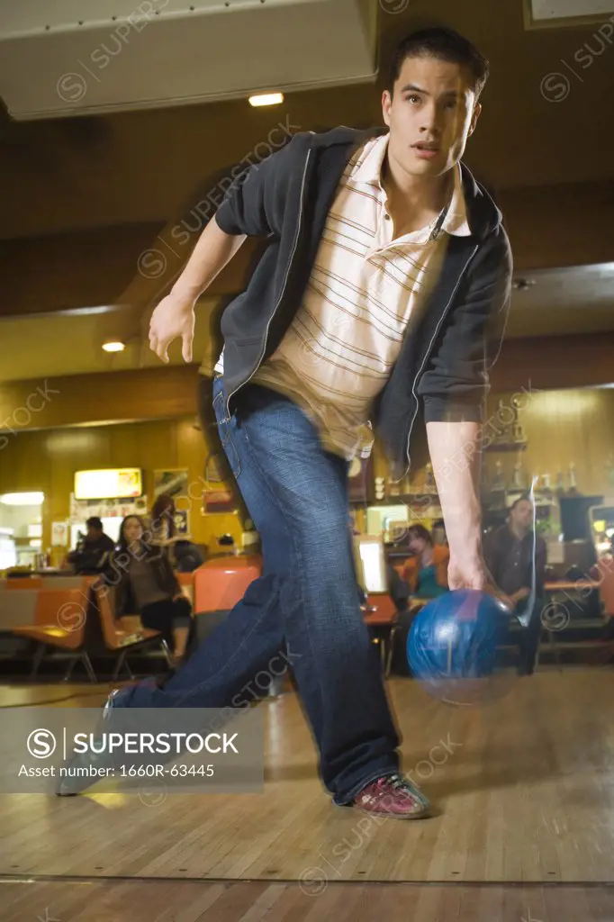 Young man bowling in a bowling alley