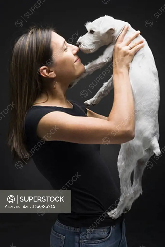 Profile of a young woman playing with her dog