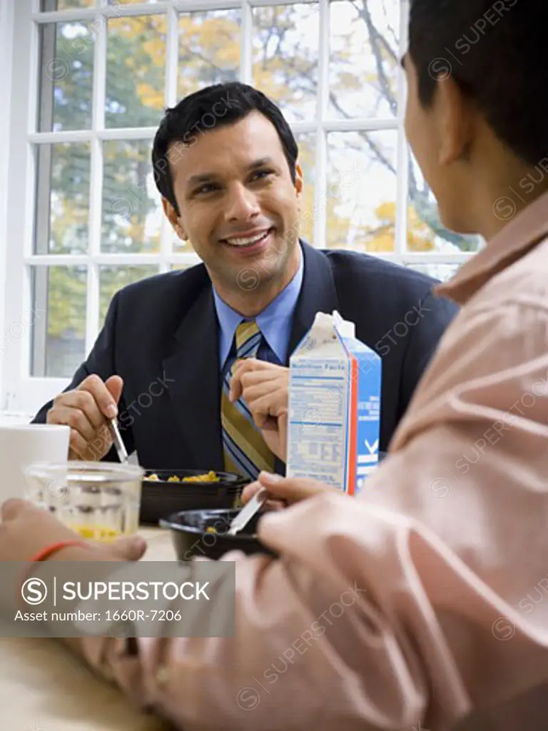 Father sitting at a breakfast table with his son