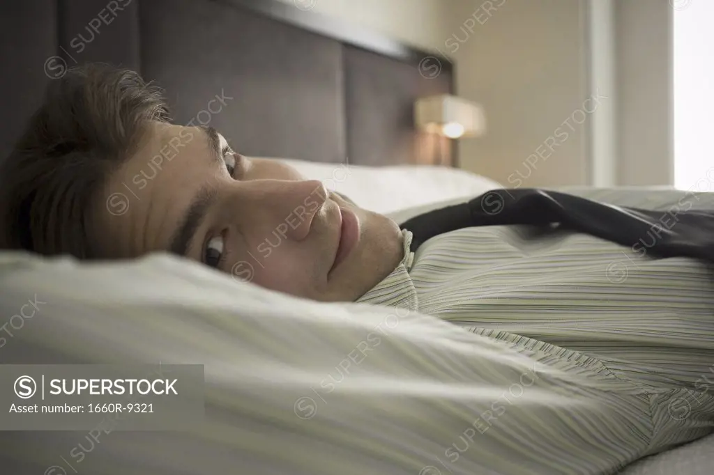 Portrait of a businessman lying on the bed