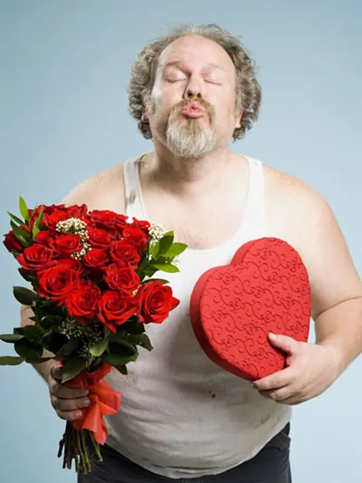 Disheveled man with red roses and heart box puckering