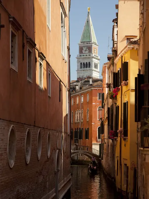 Italy, Venice, man in gondola, narrow canal and buildings