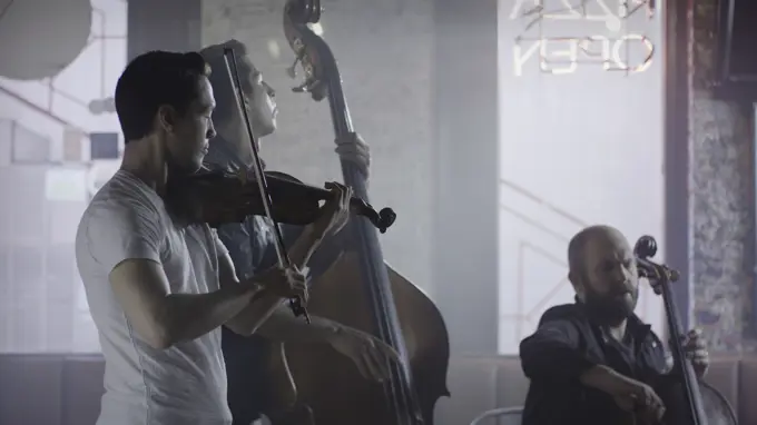 Serious musician playing violin in band in cafe