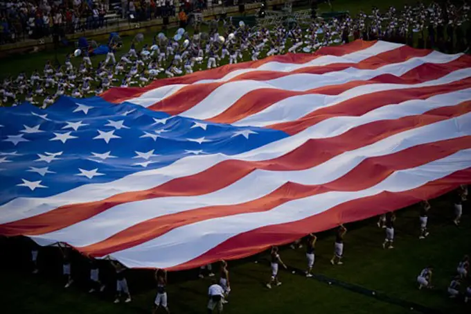 High angle view of a group of people holding a large American Flag