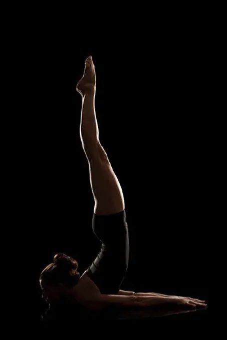 Studio shot of young woman practicing yoga