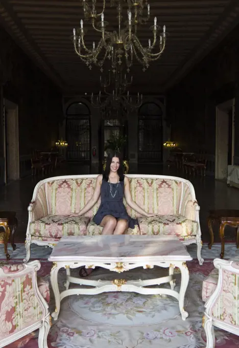 Italy, Venice, Young woman sitting in luxury room