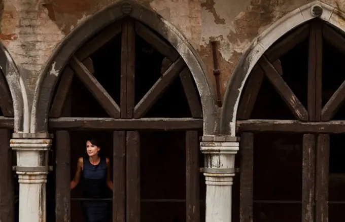 Italy, Venice, Woman standing in arcade