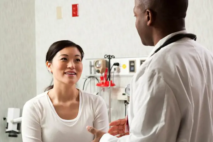 Doctor talking to woman in examining room