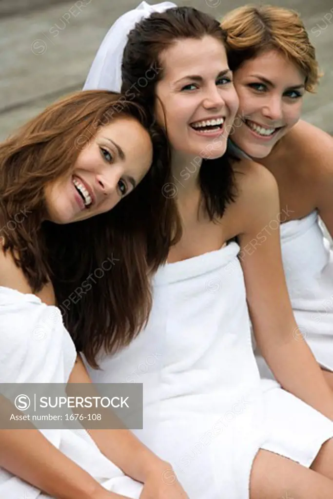 Three women wearing towels and smiling