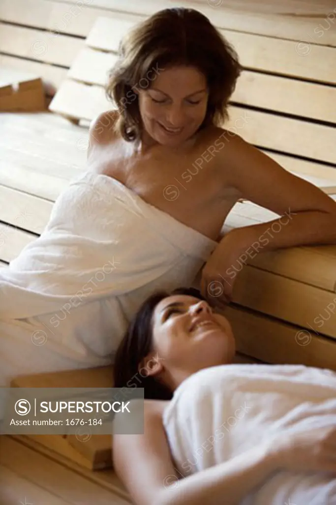 Three Mature Women Wearing Towels Sitting In A Sauna High-Res