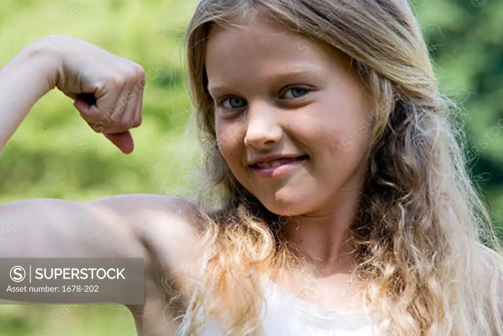 Close-up of a girl flexing her muscles