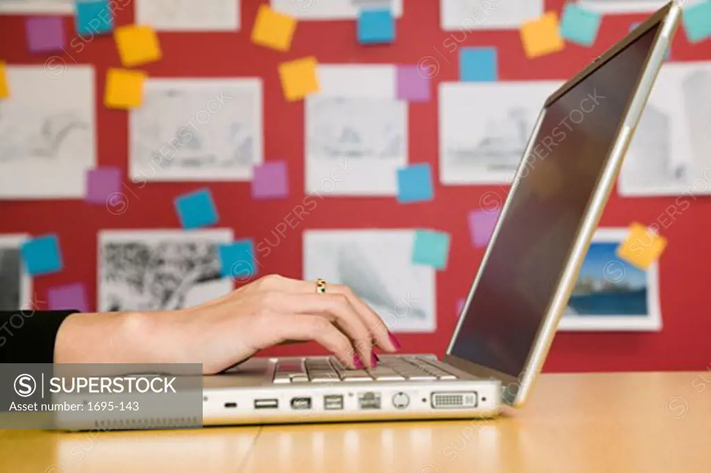 Human hand typing on a laptop