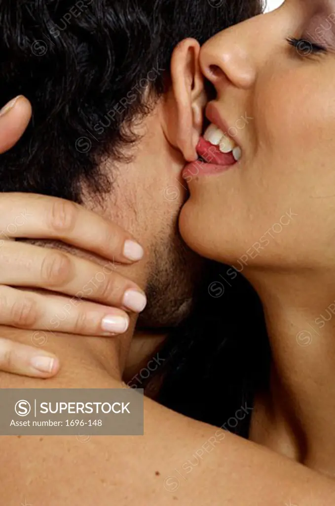 Close-up of a young woman licking a young man's ear