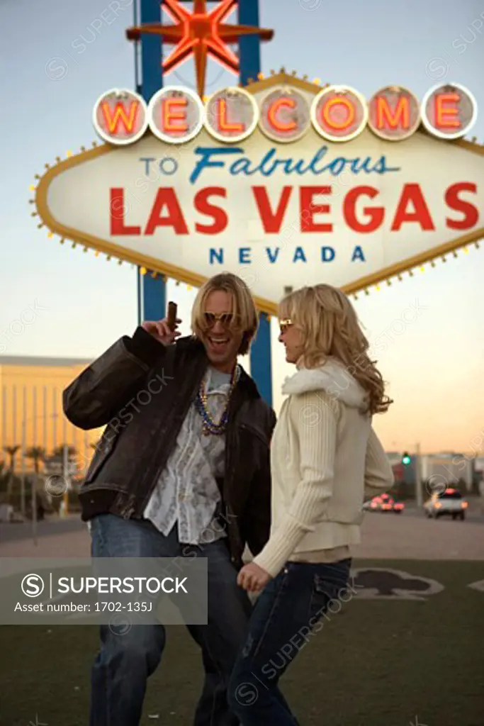 Young couple dancing in front of a welcome sign, Las Vegas, Nevada, USA