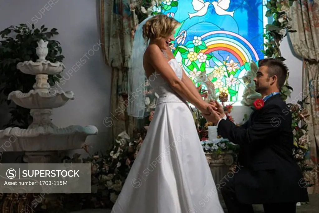 Bride and groom in front of a stained glass window