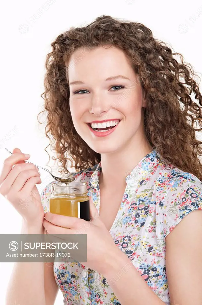 Portrait of a woman eating honey