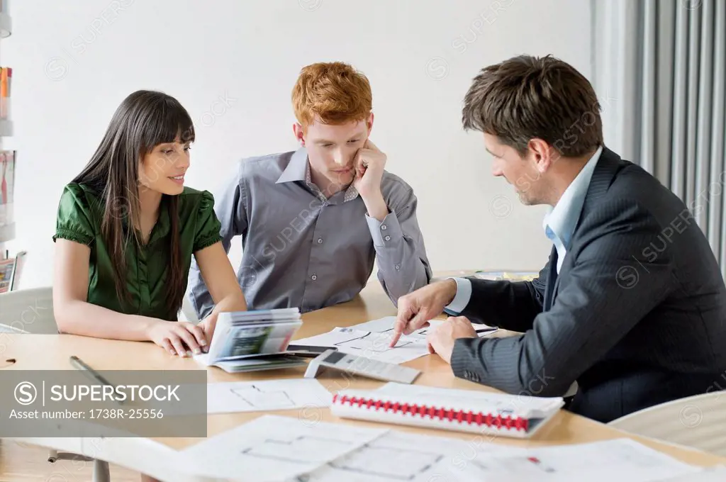 Real estate agent discussing property documents to his clients