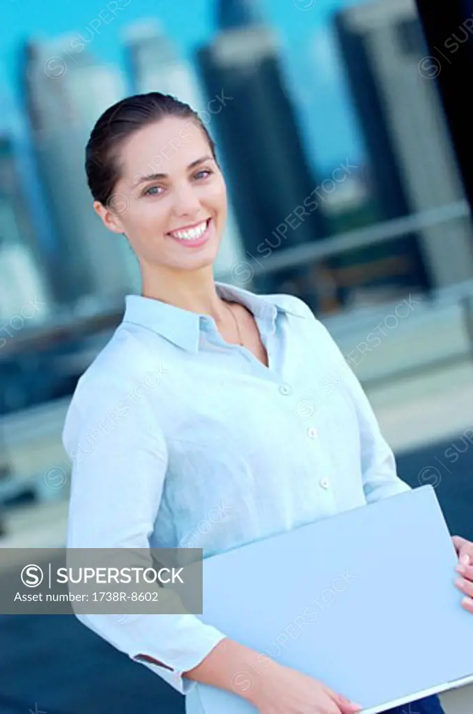 Businesswoman holding files, smiling, side view