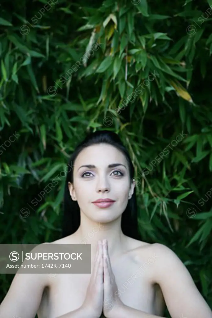 Young woman outdoors meditating.