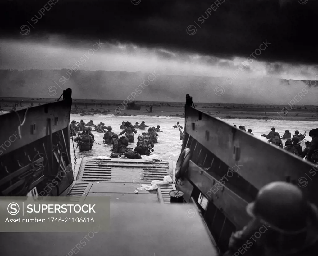 US Troops wading through water after reaching Normandy and landing Omaha beach on D Day 1944