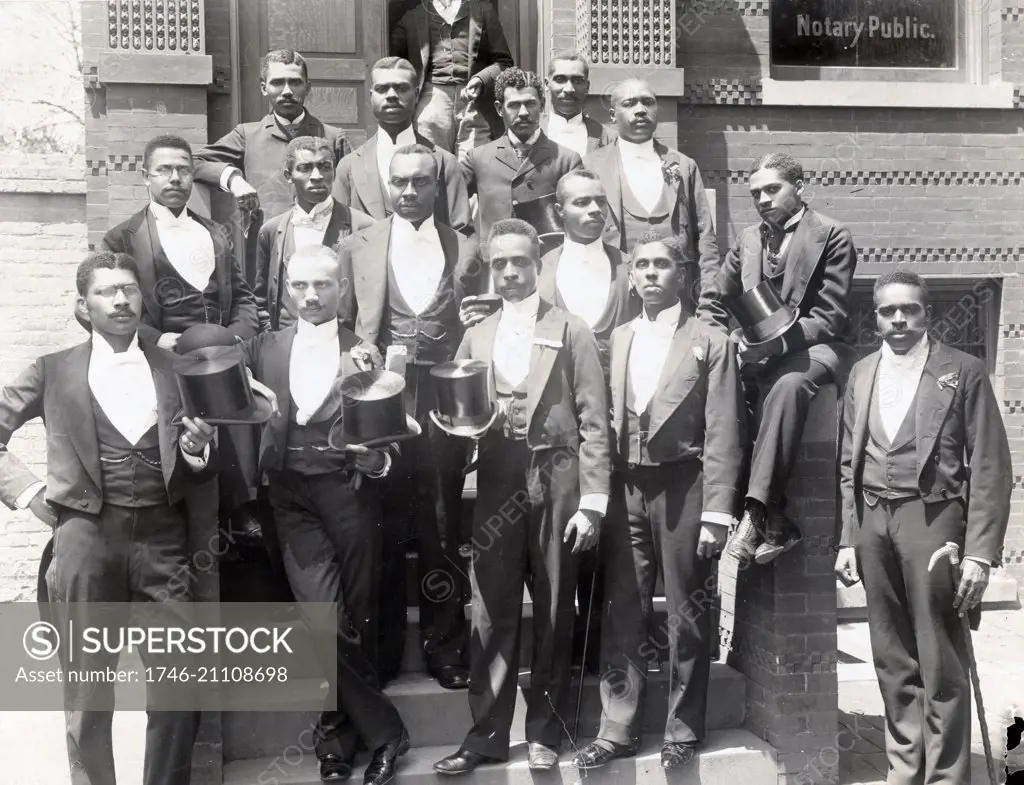 Law graduating class at Howard University, Washington DC. Sixteen African-American law students standing on steps of building, wearing formal attire, some holding top hats.