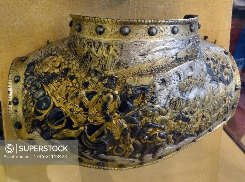 Complete Gorget, composed of two plates. The surface decoration is made of embossing in high relief, engraving, gold and silver plating and russeting. The design is representative of the Siege of a Town. French, 1615-1620.