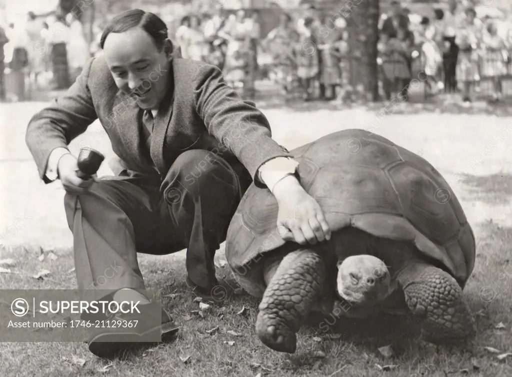 Desmond Morris with a giant tortoise on the Zootime TV programme from the London Zoo, 1956.