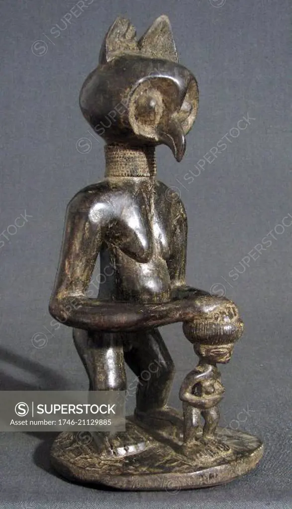 Tribal art: Owl-headed figure protecting a small child. Wood carving, Chokwe tribe, Angola, Africa. The owl as a symbol of wisdom.