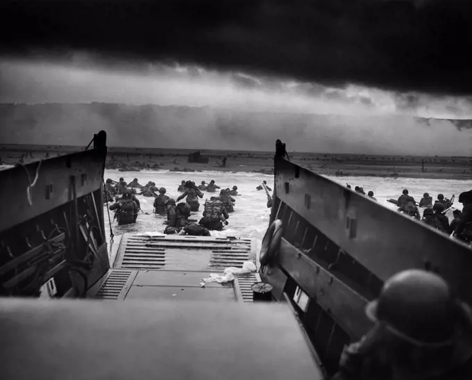 US Troops wading through water after reaching Normandy and landing Omaha beach on D Day 1944