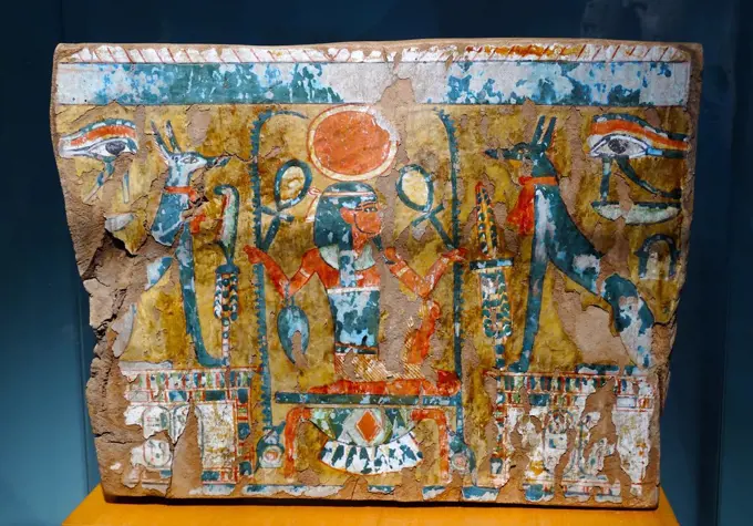 A fragment of painted wood. 21st Dynasty (1070-945 BC) from a door or coffin. In the middle of the scene is the god Heh kneeing on the sign for gold. He holds up the ankh (life) and the sign for renep (the year). This fast is on a tadpole bade (number 100.000), seated on the knot shen (eternity). The iconography is a clear allegory to the eternal life. In the hieroglyphic text appear the nomen and the praenomen of Amenhotep patron god of the artisans living at Deir el-Wledina, most probably the 