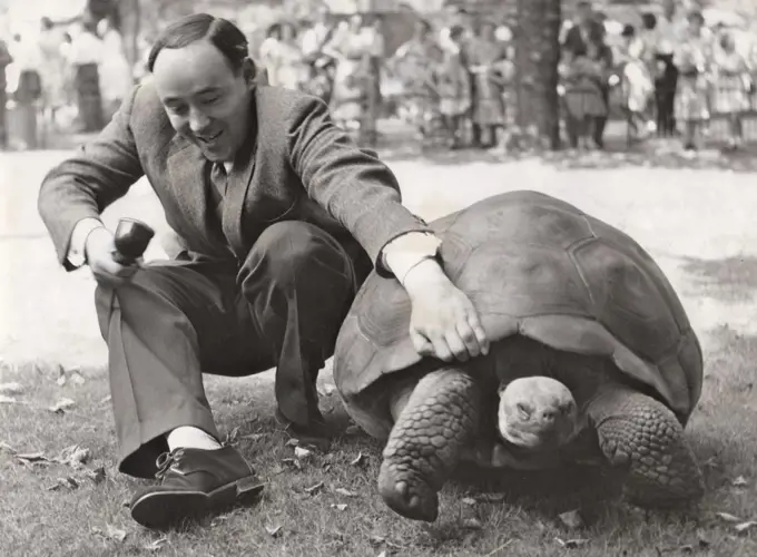 Desmond Morris with a giant tortoise on the Zootime TV programme from the London Zoo, 1956.