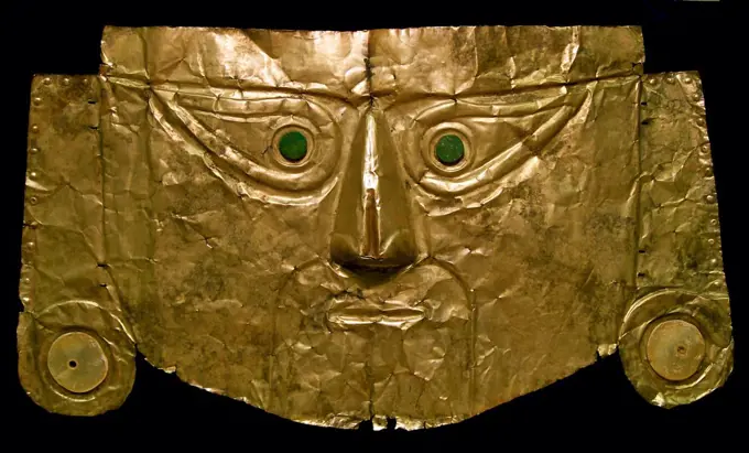 Pre-Columbian art: Chimu gold burial mask, with shell ear-plugs and dark green stone eyes, from northern Peru, 1100 - 1400 AD. This mask would have been placed on the face of a mummy.