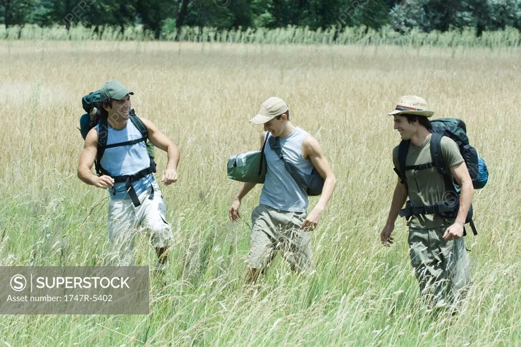 Hikers walking through field