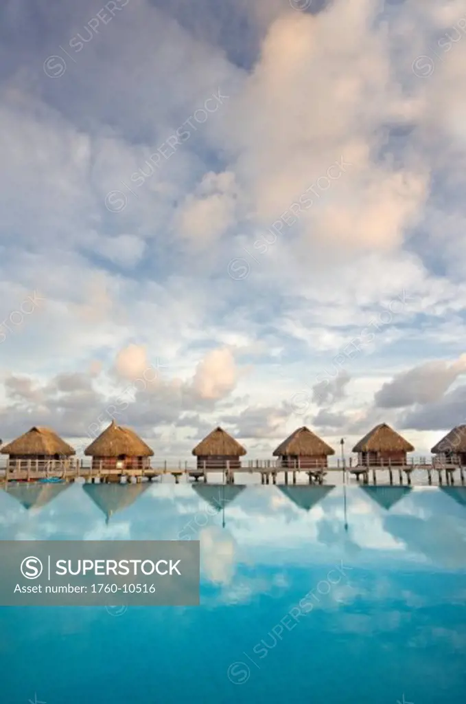 French Polynesia, Pearl Resort, Bungalows over beautiful turquoise ocean.