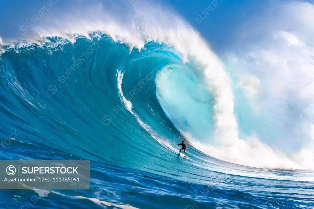 A tow-in surfer drops down the face of Hawaii's big surf at Peahi (Jaws) off North shore Maui; Maui, Hawaii, United States of America